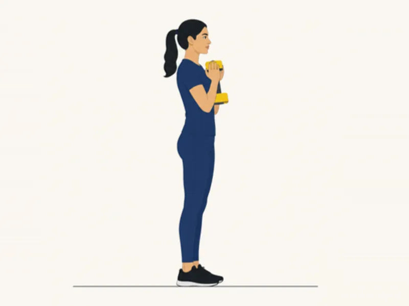 Dumbbell goblet squat: start, standing with a dumbbell held at the chest